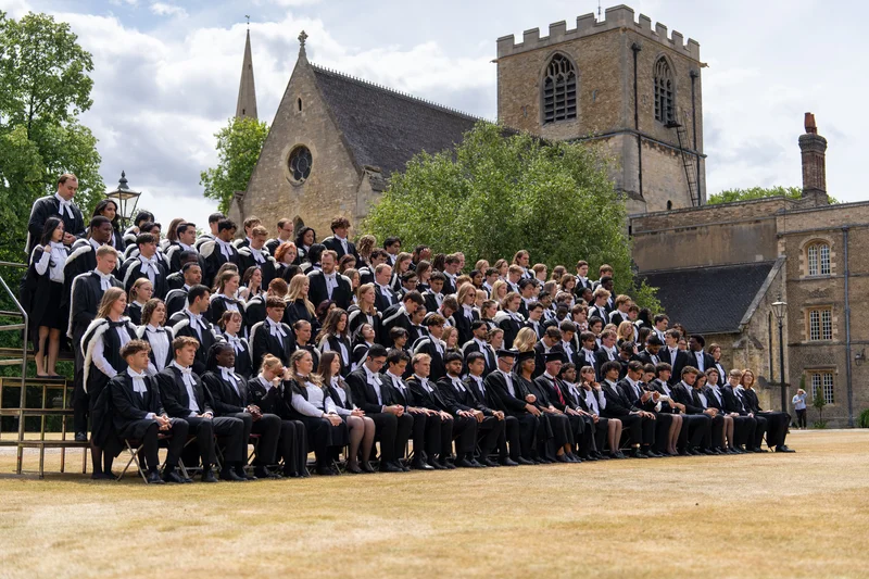 Graduates gathered in academic gowns outside Jesus College