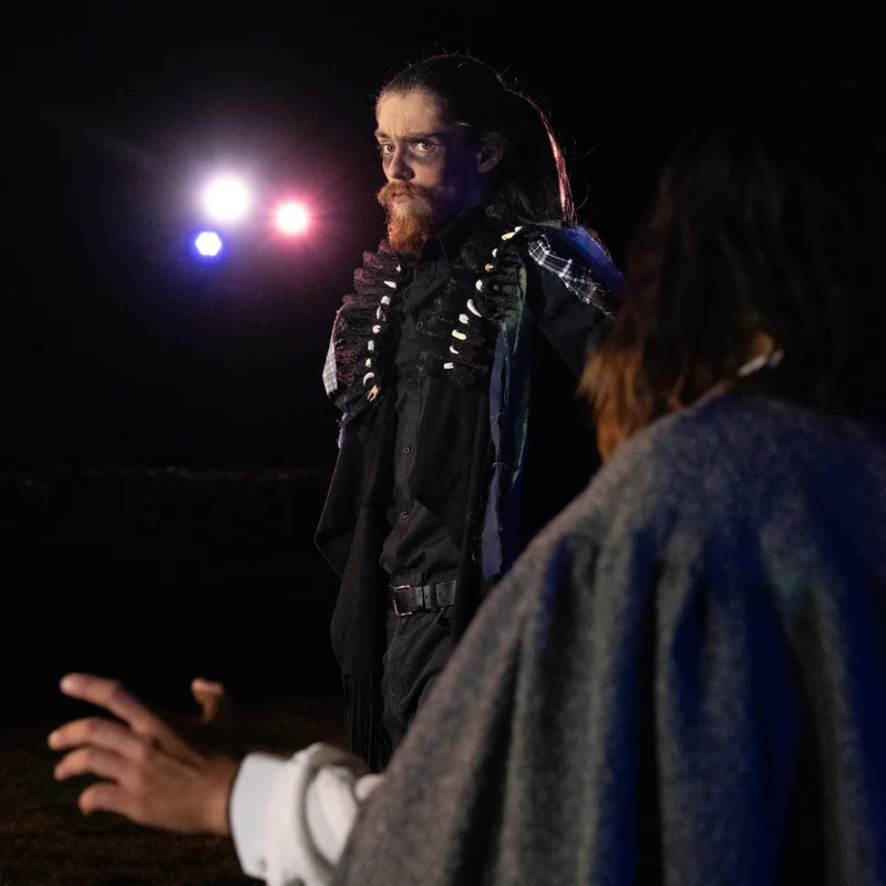 Costumed performers under coloured lights in Ruddigore