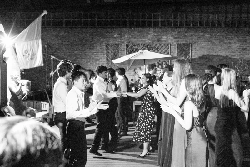 Black-and-white photograph of guests dancing at an evening celebration