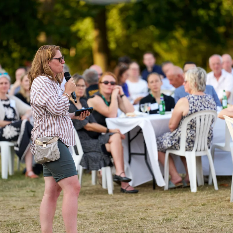 Guests chatting at tables on a lawn during an outdoor reception